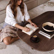 Reading and writing at the walnut coffee table — lifestyle scene