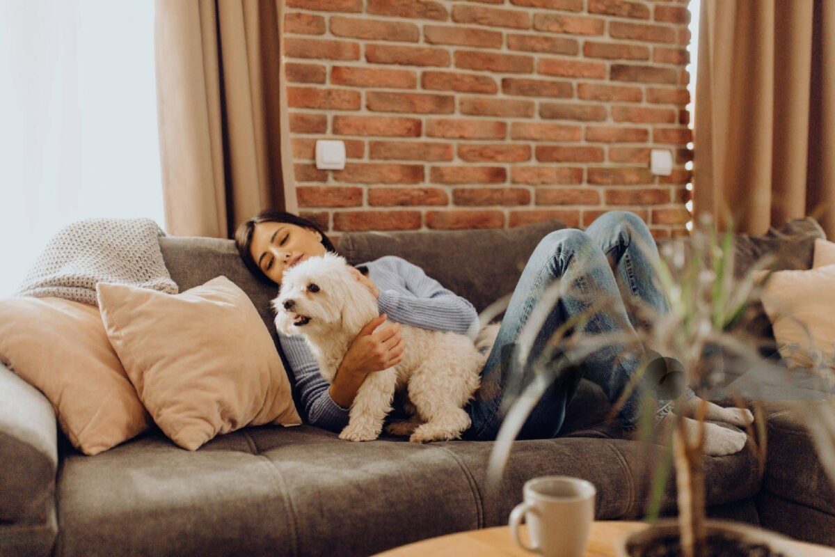 a woman and a dog are sitting a sofa-Pet-Friendly Sectional Sofa