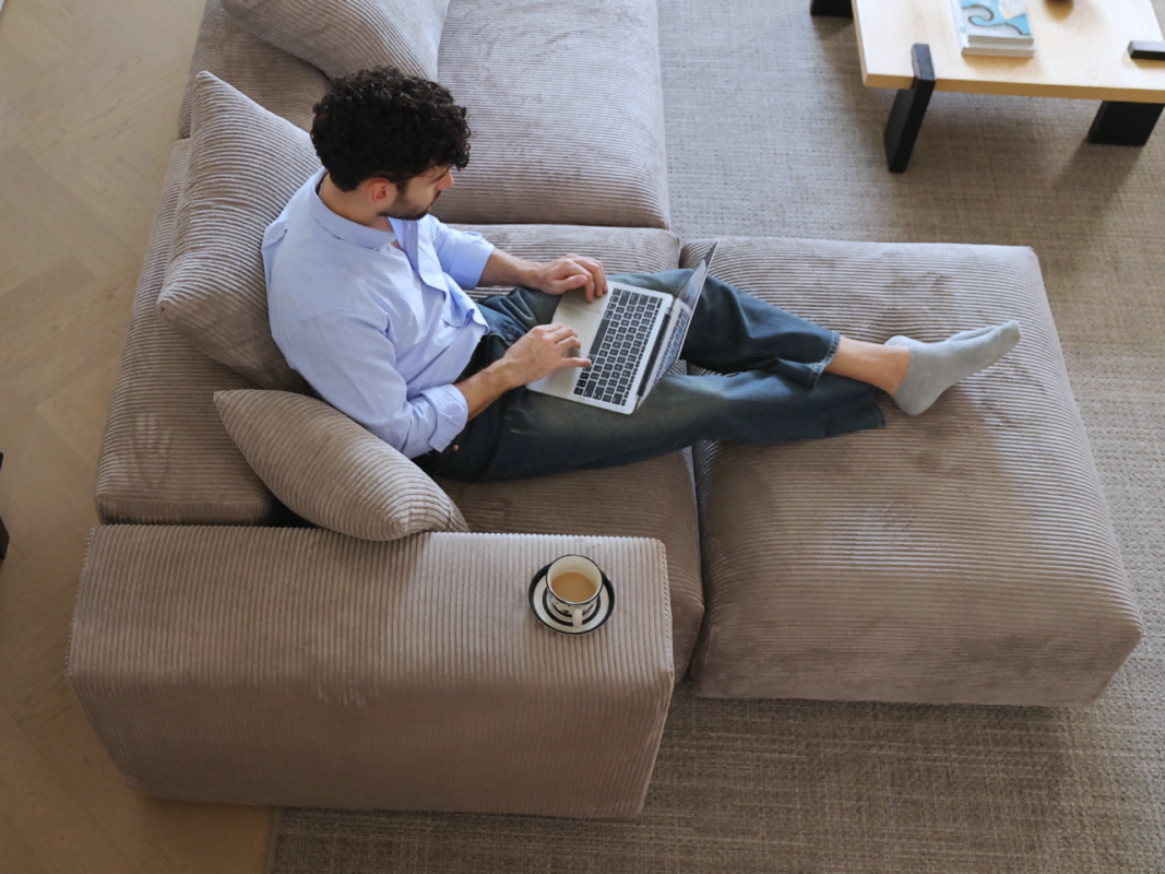 a man sits on a sofa chaise