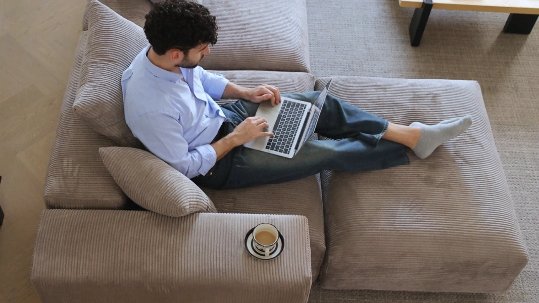 a man sits on a sectional sofa with chaise2